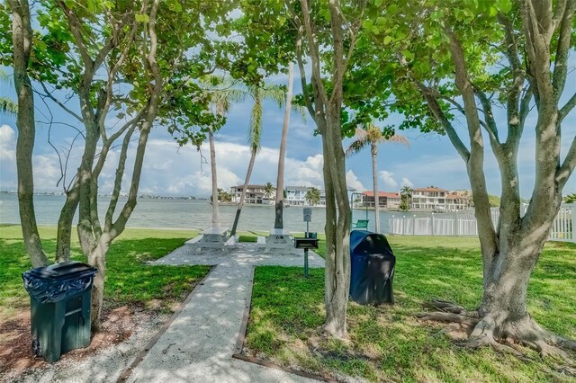 view of home's community with a water view and a yard