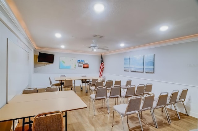 cinema room with crown molding, ceiling fan, and light wood-type flooring