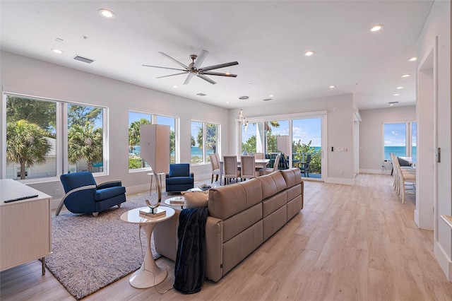 living room featuring a water view, ceiling fan, and light hardwood / wood-style floors