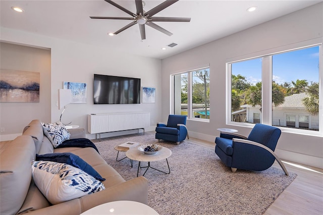 living room featuring ceiling fan, radiator, and light hardwood / wood-style floors