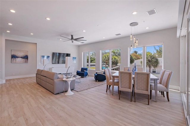 dining space with ceiling fan and light hardwood / wood-style flooring