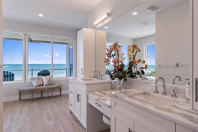 bathroom featuring a water view, vanity, and hardwood / wood-style floors