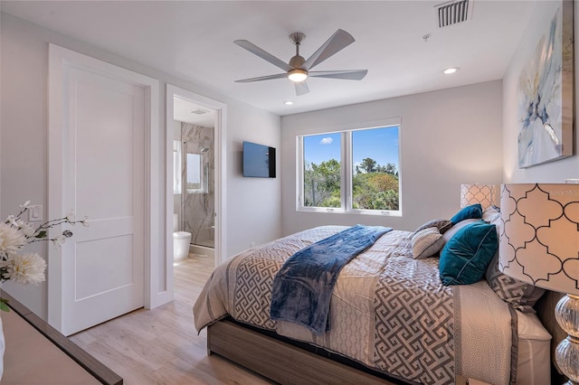 bedroom featuring ceiling fan, ensuite bathroom, and light hardwood / wood-style floors