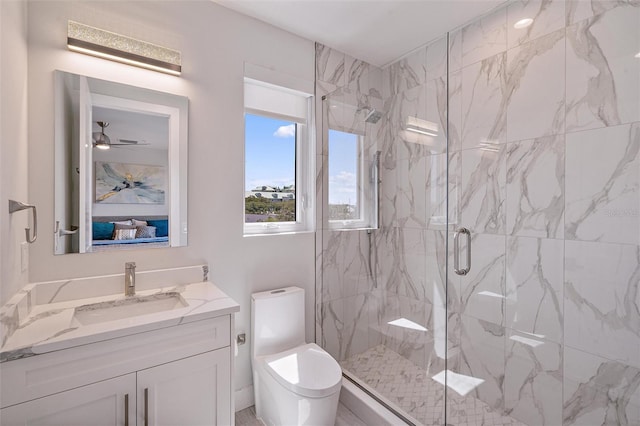 bathroom featuring toilet, vanity, and a shower with shower door