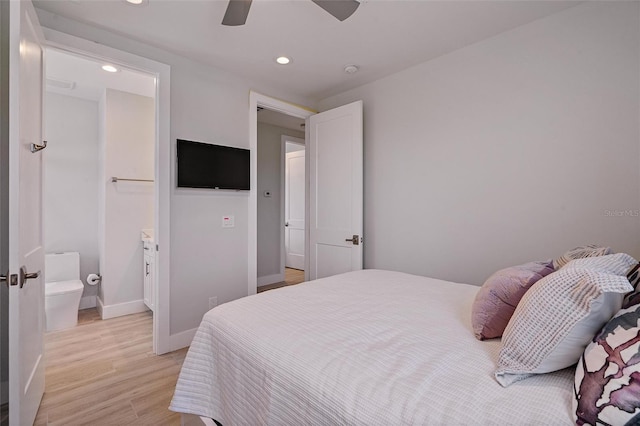 bedroom featuring light hardwood / wood-style floors, ceiling fan, and ensuite bathroom