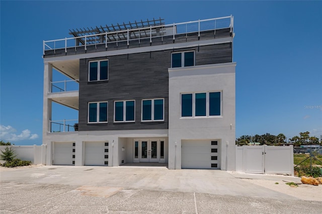 2 4th Ave, Indian Rocks Beach, FL 33785 - view of front of property featuring french doors, a garage, a balcony, and stucco siding