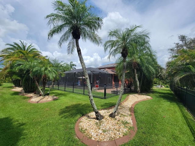 view of yard with glass enclosure and fence