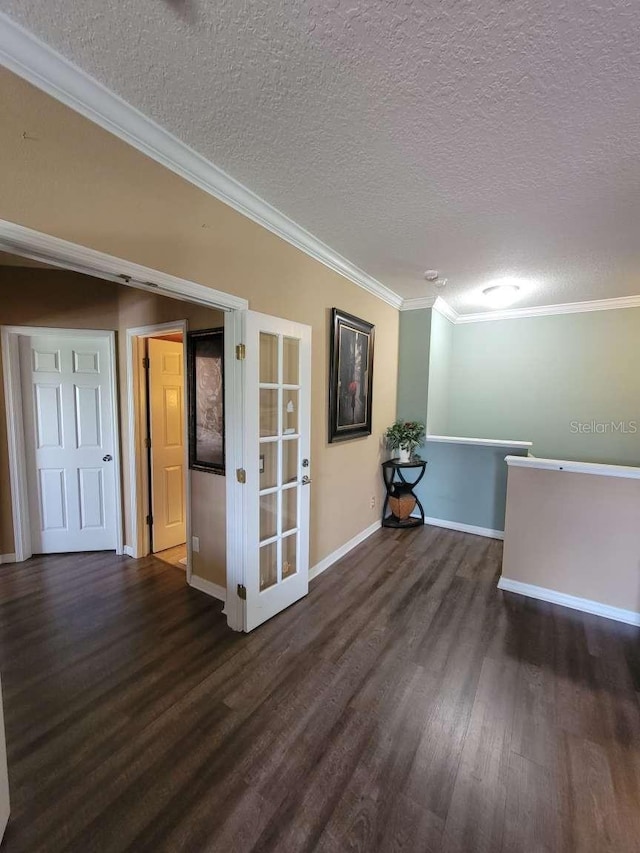 unfurnished room with a textured ceiling, french doors, ornamental molding, and dark hardwood / wood-style flooring