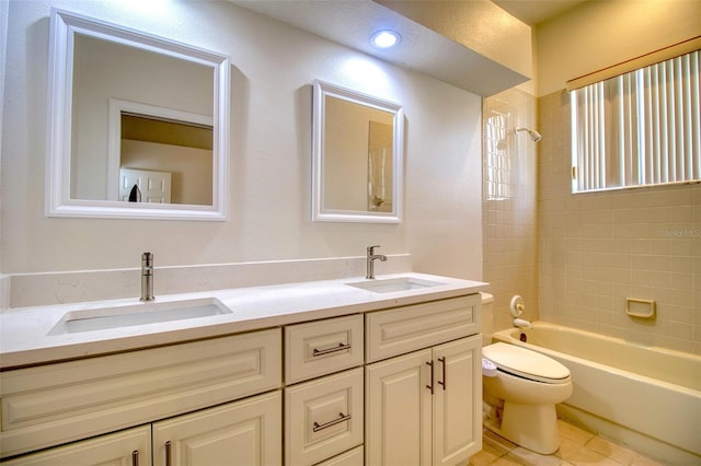 full bathroom featuring vanity, toilet, tiled shower / bath combo, and tile patterned flooring