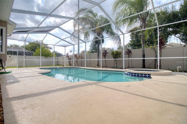 view of swimming pool with an in ground hot tub, a patio area, and a lanai