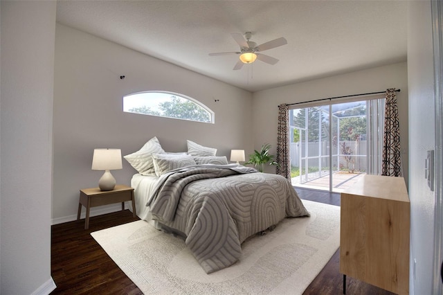 bedroom with multiple windows, access to exterior, dark wood-type flooring, and ceiling fan