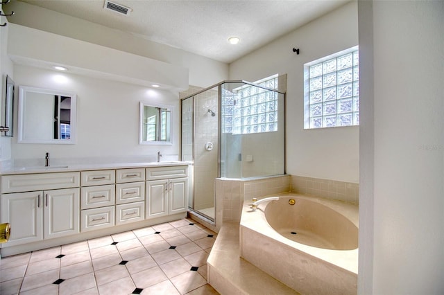 bathroom featuring vanity, a textured ceiling, independent shower and bath, and tile patterned flooring