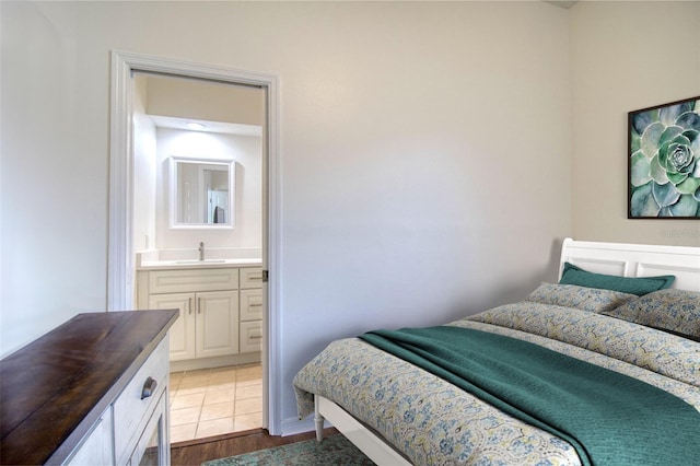 bedroom with dark hardwood / wood-style flooring, sink, and ensuite bath