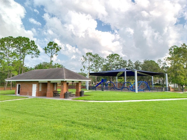 view of property's community featuring a yard, a patio area, and a playground