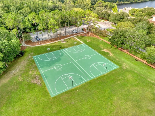 view of basketball court featuring a yard and a water view