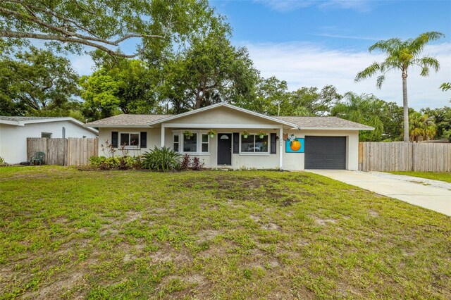 ranch-style house featuring a front yard and a garage