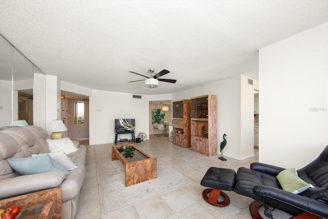 living room with a textured ceiling and ceiling fan