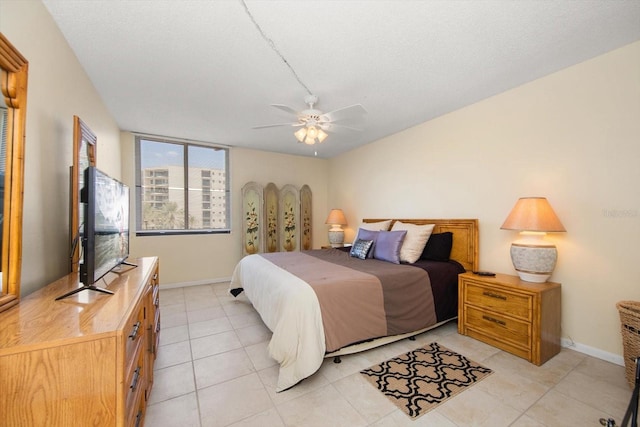 tiled bedroom with ceiling fan and a textured ceiling