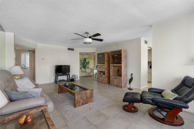 living room featuring a textured ceiling and ceiling fan