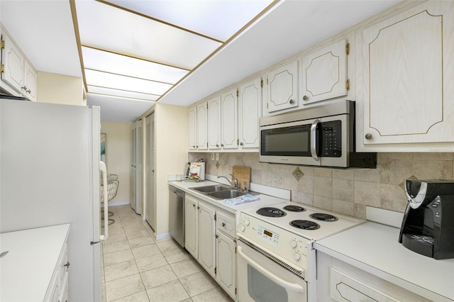 kitchen with light tile patterned flooring, appliances with stainless steel finishes, tasteful backsplash, and sink