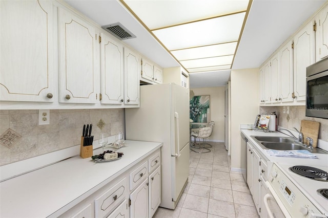 kitchen with white cabinetry, light tile patterned floors, stainless steel appliances, backsplash, and sink