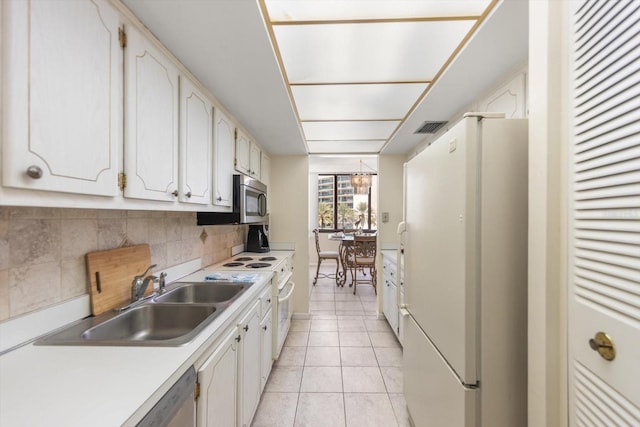 kitchen featuring tasteful backsplash, sink, white appliances, white cabinetry, and light tile patterned flooring