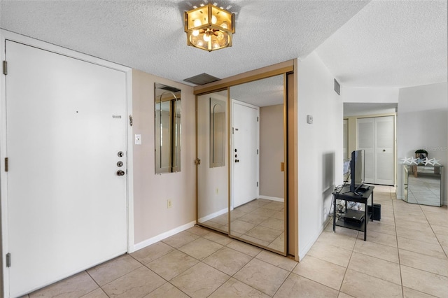 entryway featuring a textured ceiling and light tile patterned floors