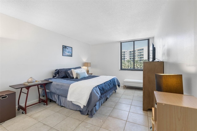 bedroom with a textured ceiling and light tile patterned floors