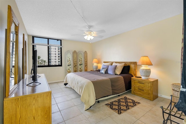 tiled bedroom featuring ceiling fan and a textured ceiling