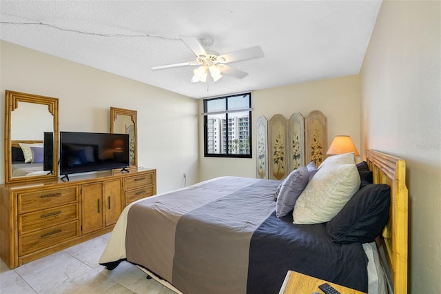 bedroom with ceiling fan and a textured ceiling