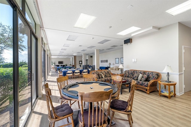 dining space with a wealth of natural light, a textured ceiling, and light hardwood / wood-style floors