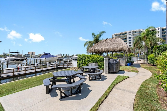 view of community with a gazebo, a water view, and a boat dock