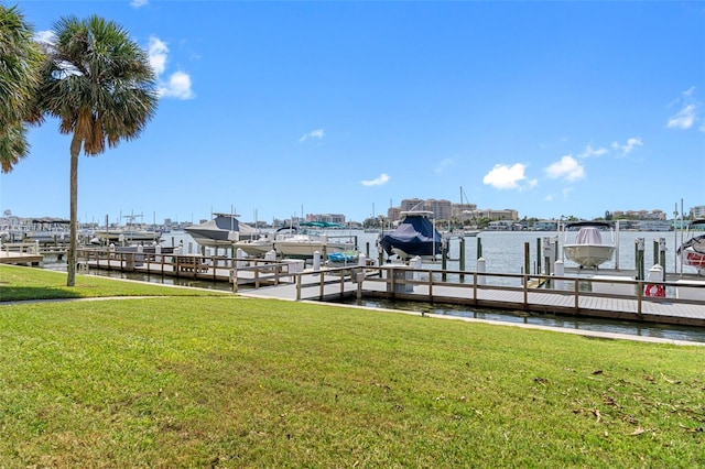 view of dock with a yard and a water view