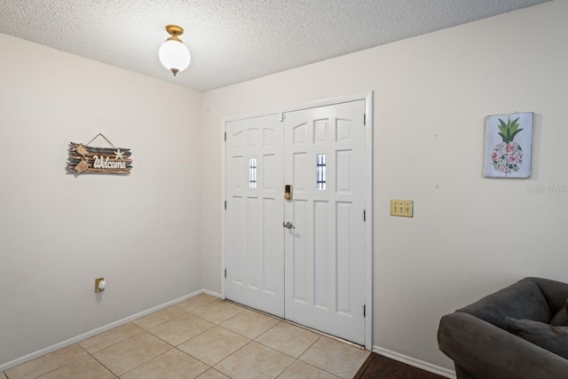 tiled entryway featuring a textured ceiling