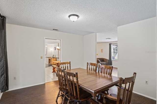 dining area with a textured ceiling and hardwood / wood-style floors