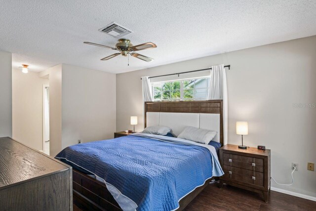 12912 Willoughby Ln, Hudson, FL 34667 - bedroom with visible vents, wood finished floors, baseboards, ceiling fan, and a textured ceiling