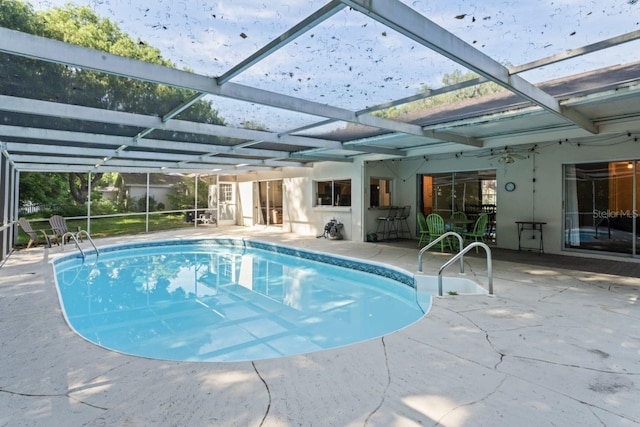 view of swimming pool with glass enclosure and a patio area