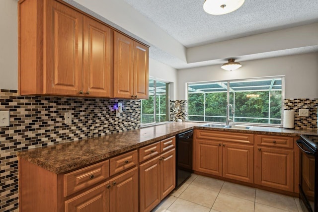 kitchen featuring a textured ceiling, black appliances, dark stone countertops, backsplash, and sink