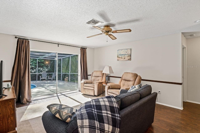 living room with ceiling fan, a textured ceiling, and wood-type flooring