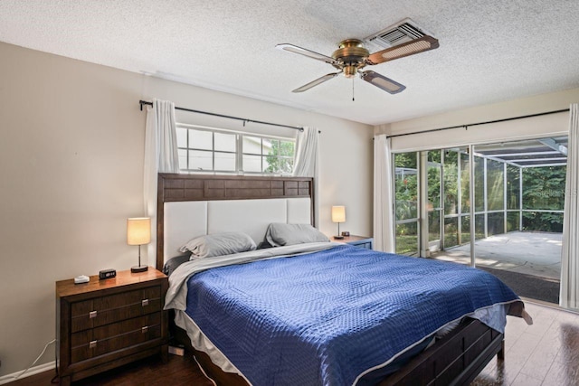 bedroom with ceiling fan, a textured ceiling, access to outside, and hardwood / wood-style flooring