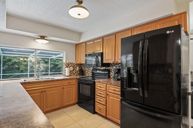 kitchen with tasteful backsplash, a textured ceiling, light tile patterned floors, black appliances, and sink