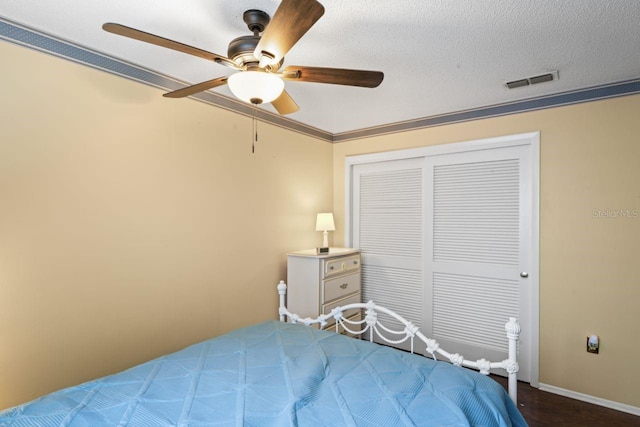 bedroom featuring ceiling fan, a textured ceiling, a closet, and hardwood / wood-style floors