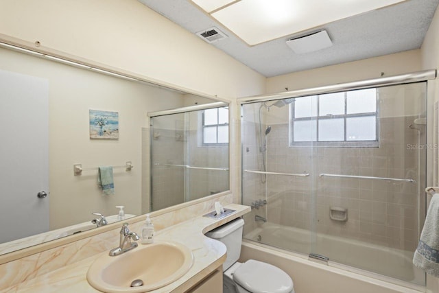 full bathroom featuring shower / bath combination with glass door, vanity, and toilet