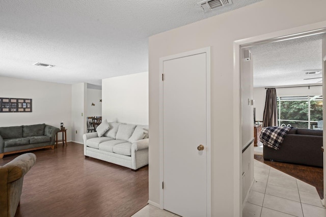 12912 Willoughby Ln, Hudson, FL 34667 - living room with visible vents, baseboards, a textured ceiling, and wood finished floors