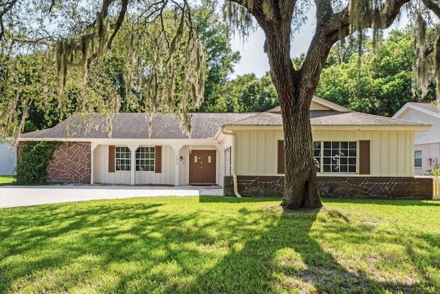 12912 Willoughby Ln, Hudson, FL 34667 - ranch-style home with board and batten siding, a shingled roof, and a front lawn