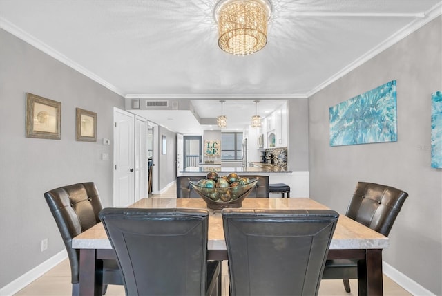 dining space featuring crown molding, a chandelier, and light hardwood / wood-style flooring