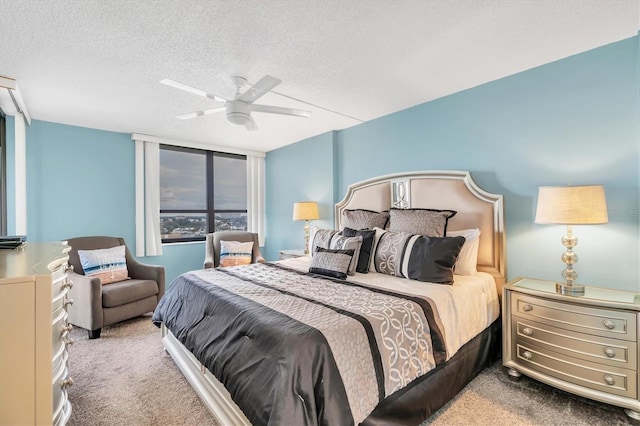 bedroom with ceiling fan, carpet floors, and a textured ceiling