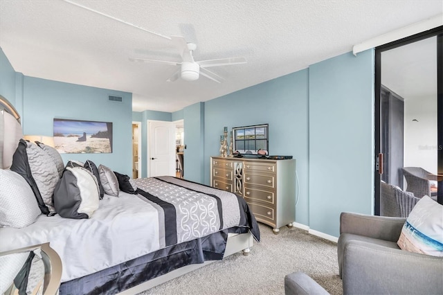 bedroom with ceiling fan, carpet flooring, and a textured ceiling