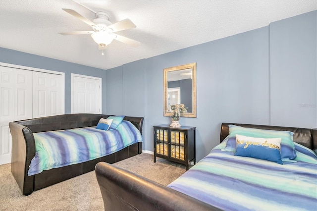 carpeted bedroom with ceiling fan and a textured ceiling