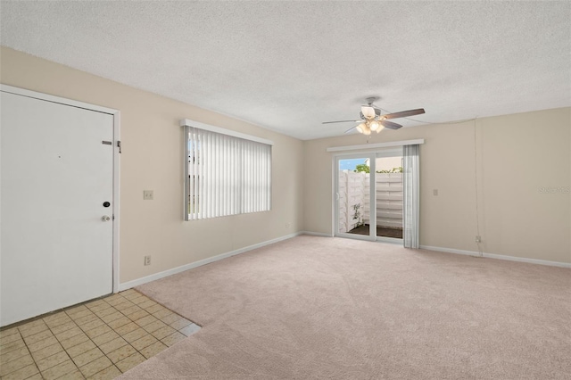 carpeted spare room with a textured ceiling and ceiling fan